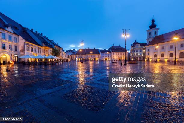 wet grand square at sunset in sibiu, romania - sibiu stock-fotos und bilder