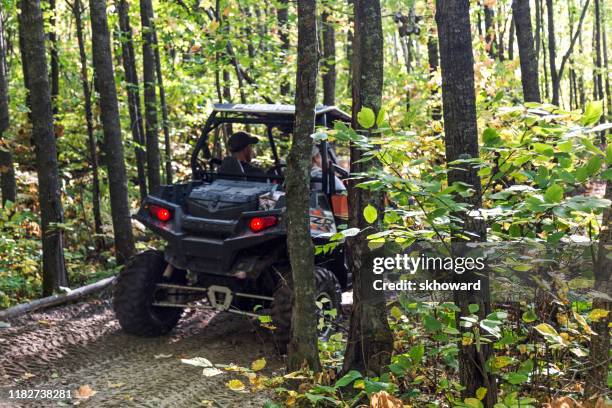 trail riding on 4x4 side-by-side off-road vehicle - side by side atv stock pictures, royalty-free photos & images