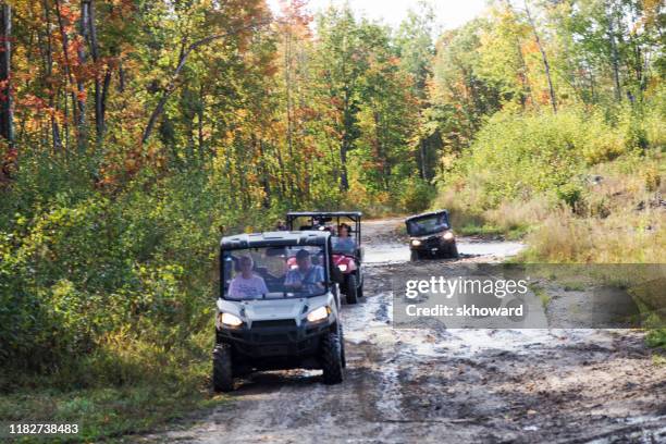 trail riding on 4x4 side-by-side off-road vehicles - side by side atv stock pictures, royalty-free photos & images