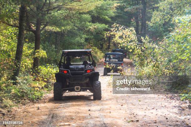 trail riding on 4x4 side-by-side off-road vehicles - side by side atv stock pictures, royalty-free photos & images