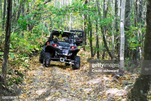 trail riding on 4x4 side-by-side off-road vehicles - side by side atv stock pictures, royalty-free photos & images