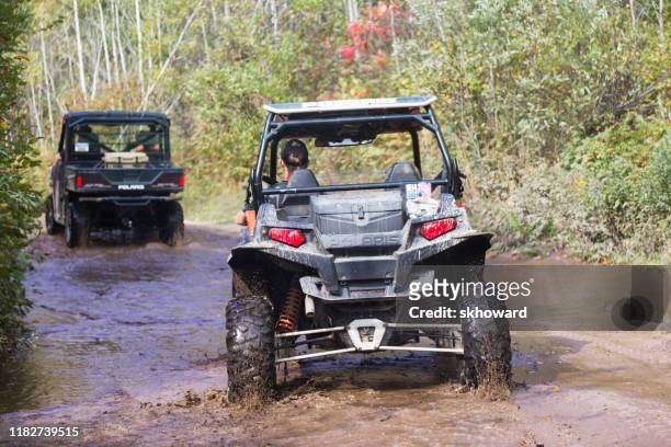trail riding on 4x4 side-by-side off-road vehicles - side by side atv stock pictures, royalty-free photos & images