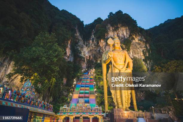 statue of lord murugan outside batu caves in malaysia - batu caves stock pictures, royalty-free photos & images