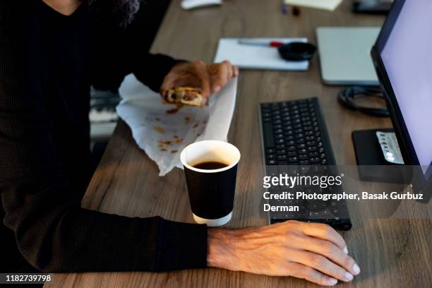 unhealthy eating in the office - breakfast to go stock-fotos und bilder