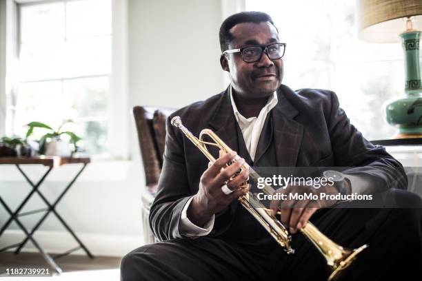 senior man laughing holding trumpet - jazz musician foto e immagini stock