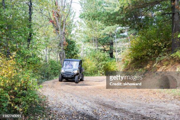 trail riding on 4x4 side-by-side off-road vehicle - side by side atv stock pictures, royalty-free photos & images