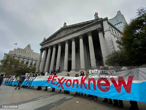 October 22: People take part in a protest against ExxonMobil before the start of its trial outside the New York State Supreme Court building on...