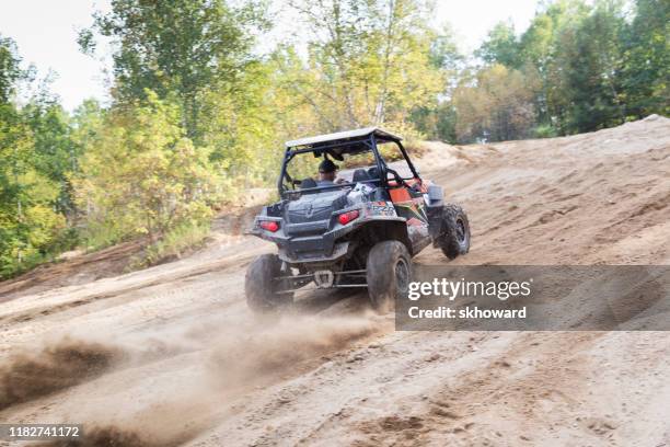 sand pit riding on 4x4 side-by-side off-road vehicle - side by side atv stock pictures, royalty-free photos & images