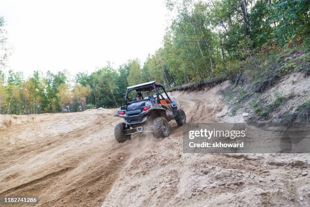 sand pit riding on 4x4 side-by-side off-road vehicle - side by side atv stock pictures, royalty-free photos & images