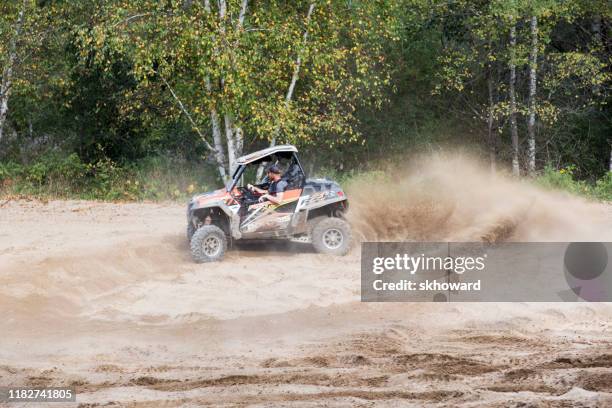 sand pit riding on 4x4 side-by-side off-road vehicle - side by side atv stock pictures, royalty-free photos & images