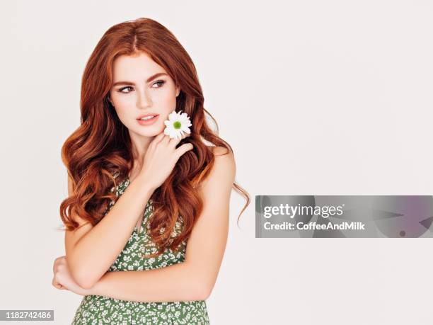 beautiful woman with red hair holding a flower - beautiful woman white background stock pictures, royalty-free photos & images