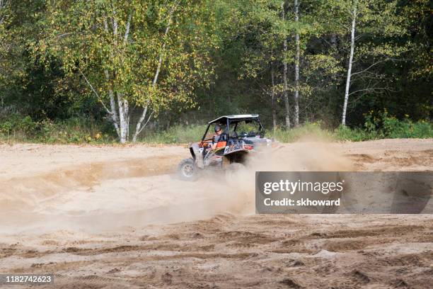 sand pit riding on 4x4 side-by-side off-road vehicle - side by side atv stock pictures, royalty-free photos & images