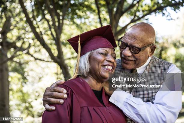 senior woman in college graduation gown with husband - graduation gown 個照片及圖片檔