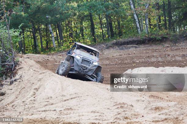 sand pit riding on 4x4 side-by-side off-road vehicle - side by side atv stock pictures, royalty-free photos & images