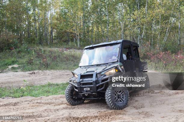 sand pit riding on 4x4 side-by-side off-road vehicle - side by side atv stock pictures, royalty-free photos & images