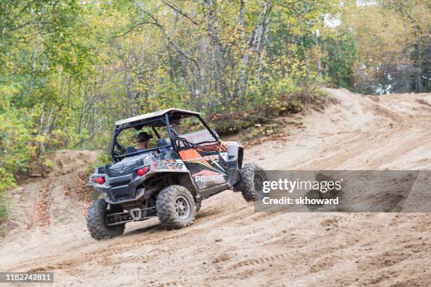 sand pit riding on 4x4 side-by-side off-road vehicle - side by side atv stock pictures, royalty-free photos & images