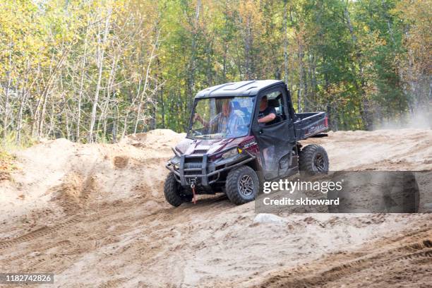 sand pit riding on 4x4 side-by-side off-road vehicle - side by side atv stock pictures, royalty-free photos & images