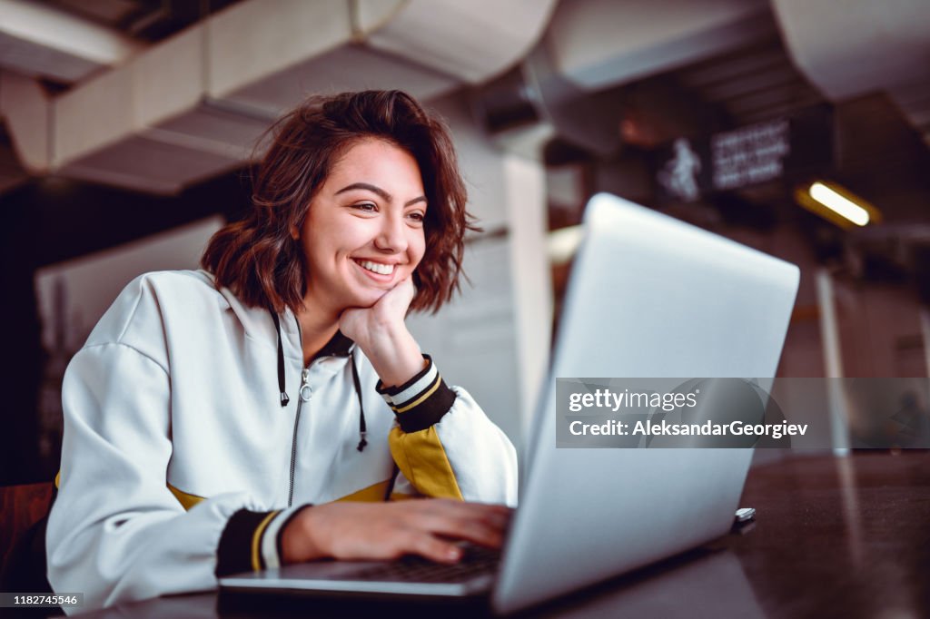 Mujer hispana estudiando en el ordenador portátil