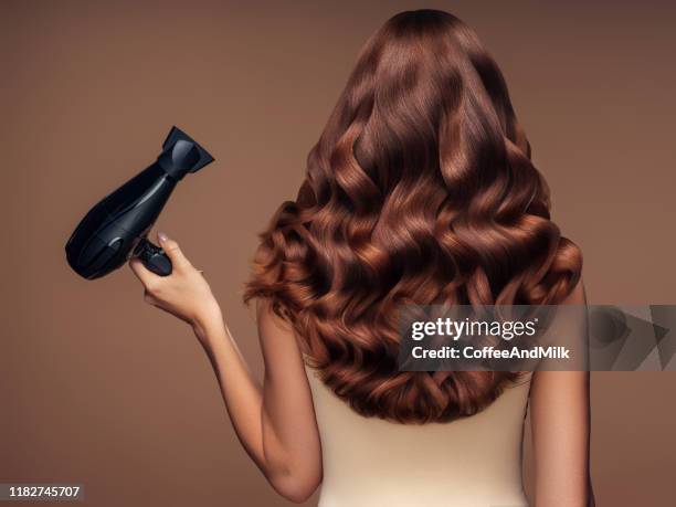 girl with a beautiful hairstyle holding a hairdryer - hair dryer stock pictures, royalty-free photos & images