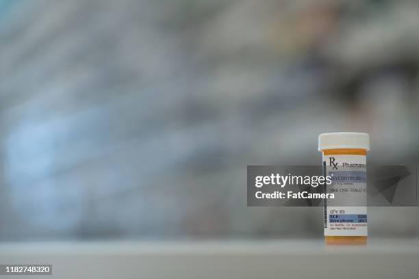 single prescription pill bottle on a counter stock photo - pill bottle stock pictures, royalty-free photos & images
