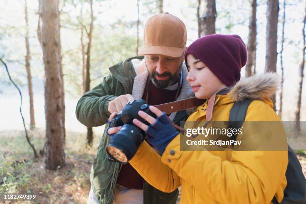 father teaches his son how to use a camera - boy taking picture in forest stock pictures, royalty-free photos & images