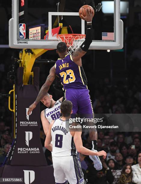 LeBron James of the Los Angeles Lakers dunks over Nemanja Bjelica of the Sacramento Kings during the first half at Staples Center on November 15,...