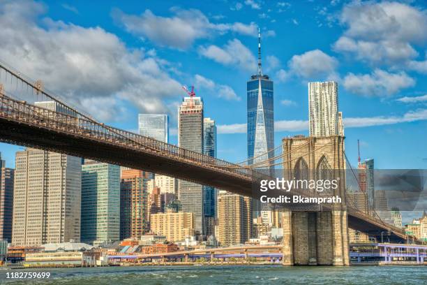 downtown manhattan with the brooklyn bridge and world trade center as seen from dumbo brooklyn new york city - new york state stock pictures, royalty-free photos & images