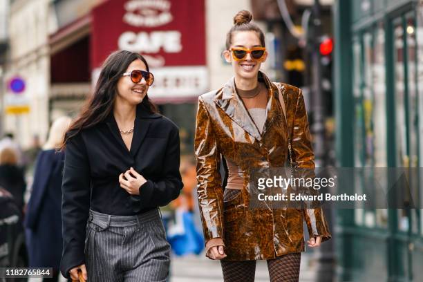 Doina Ciobanu wears sunglasses, a necklace, a black shirt, grey pants with thin white stripes ; Estelle Chemouny wears sunglasses, a see-through...