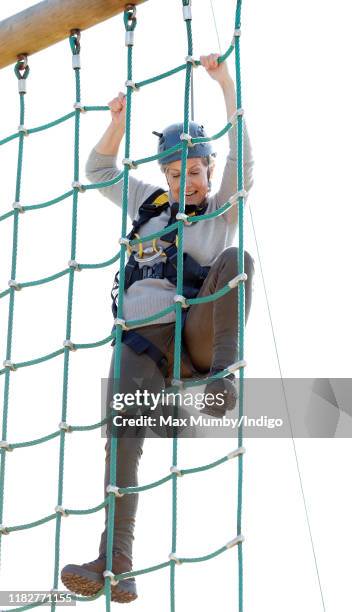 Sophie, Countess of Wessex wears a climbing harness and helmet as she tries out a high-wire assault course during The Countess of Wessex Cup 2019 at...