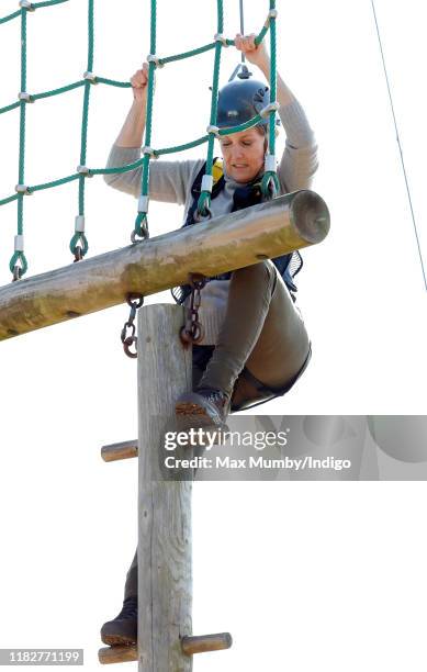 Sophie, Countess of Wessex wears a climbing harness and helmet as she tries out a high-wire assault course during The Countess of Wessex Cup 2019 at...