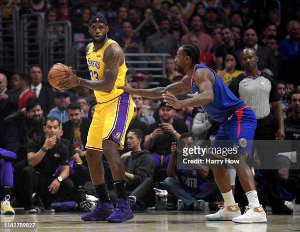 LeBron James of the Los Angeles Lakers is defended by Kawhi Leonard of the LA Clippers during the first half in the LA Clippers season home opener at...