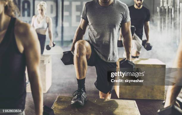 unrecognizable male athlete having cross training with dumbbells in a gym. - hand weight stock pictures, royalty-free photos & images