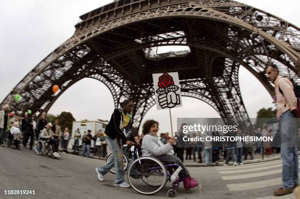 Personnes handicapées et valides participent, le 24 septembre 2005 à Paris, à un défilé aux pieds de la tour Eiffel, aux rythmes et couleurs...
