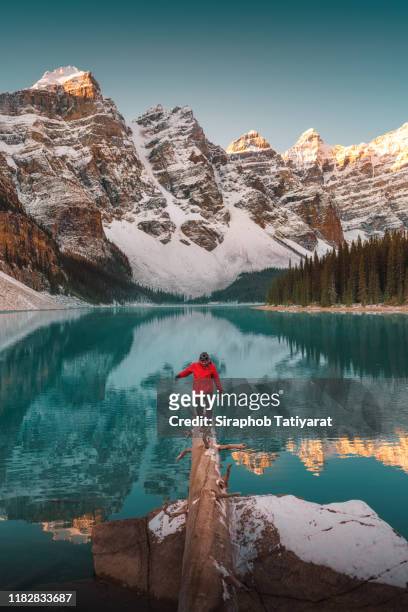 man at moraine lake at sunrise, banff, canada - canadian rocky mountains snow stock-fotos und bilder