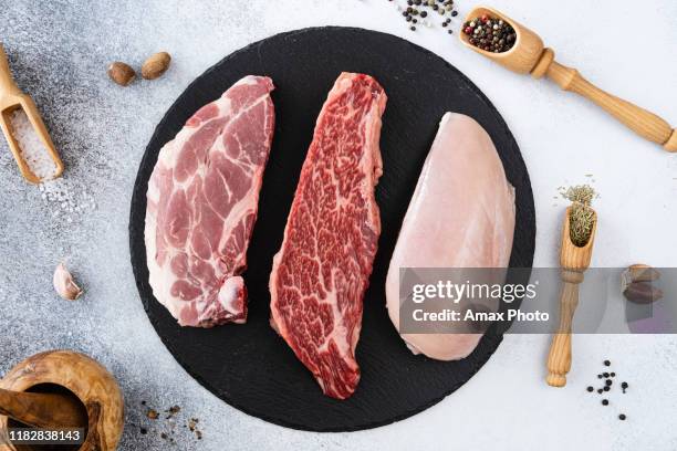 carnes cruas frescas da carne, carne de porco e peito de galinha com peppercorns, temperos e especiarias, aprontam-se para grelhar. vista superior - cru - fotografias e filmes do acervo