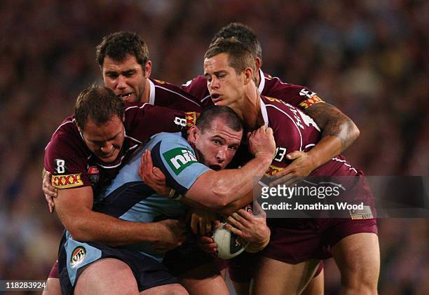 Paul Gallen of the Blues is tackled during game three of the ARL State of Origin series between the Queensland Maroons and the New South Wales Blues...