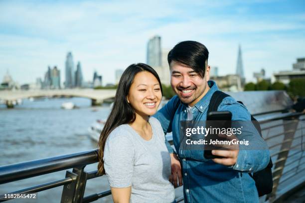 bekymmerslöst unga kinesiska turister poserar för selfie i london - land i sikte bildbanksfoton och bilder