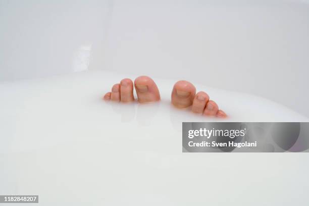 woman's toes poking out of a milk bath - pretty toes and feet stock-fotos und bilder