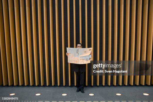 a businessman reading the newspaper - center for asian american media stock pictures, royalty-free photos & images