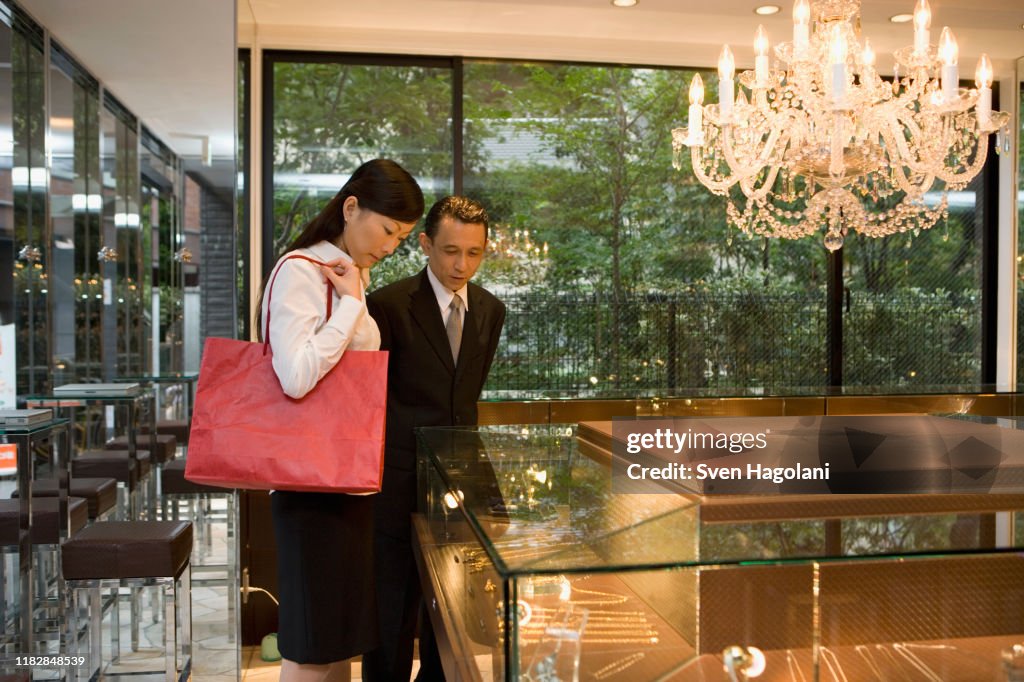 Two people looking at jewelry in display cabinets
