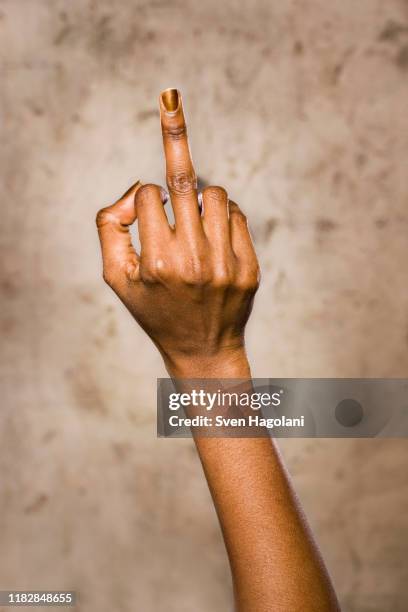 a woman giving an obscene hand gesture - obscene gesture fotografías e imágenes de stock