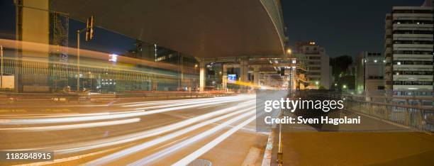 traffic passing on a road at night, tokyo, japan - バイパス ストックフォトと画像