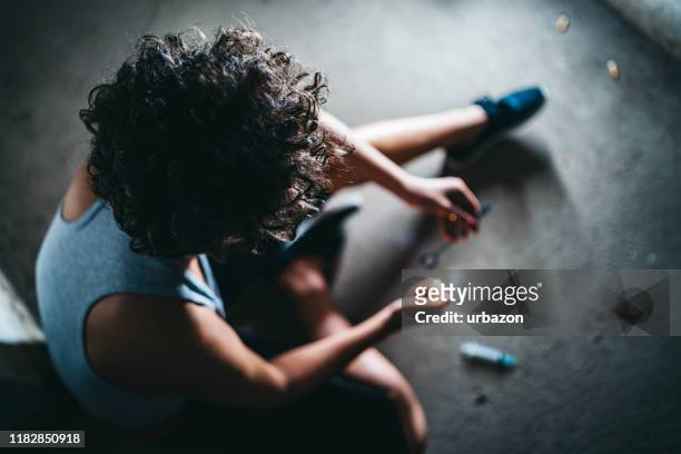 female addict preparing heroin dose - opióide imagens e fotografias de stock