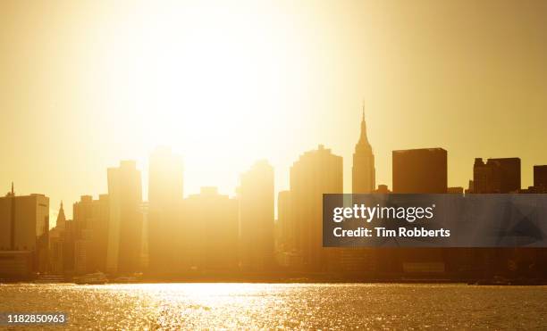 east river, midtown manhattan and empire states building at sunset - new york spring spectacular stock-fotos und bilder