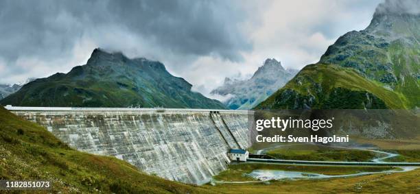 a dam amongst the mountains of tirol, austria - reservoir stock-fotos und bilder