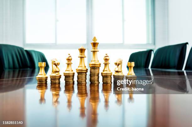 schaakstukken staan op de gestapelde munten - chess king stockfoto's en -beelden