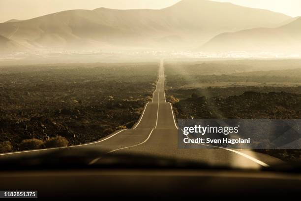 rolling road leading to mountains in lanzarote, canary islands, spain - spain landscape stock pictures, royalty-free photos & images