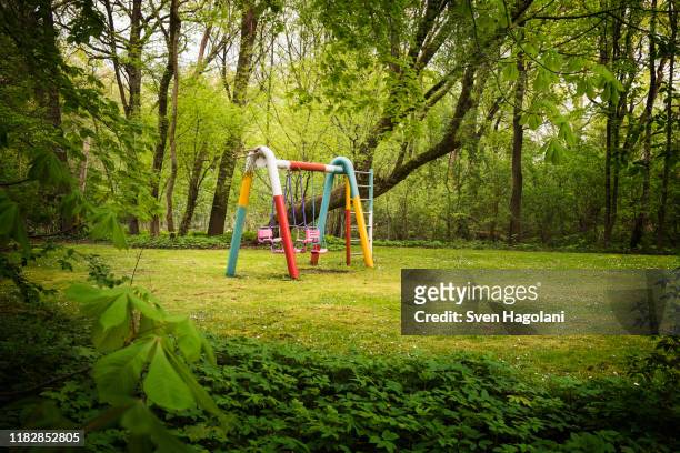 empty swings in park - kinderspielplatz stock-fotos und bilder