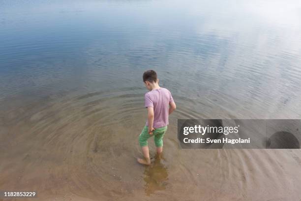 high angle view of boy standing in lake - 9 loch stock pictures, royalty-free photos & images