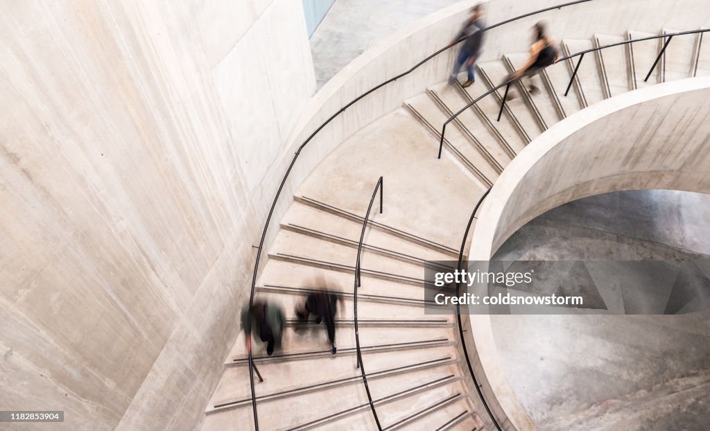 Verschwommene Bewegung von Menschen auf Spiraltreppe